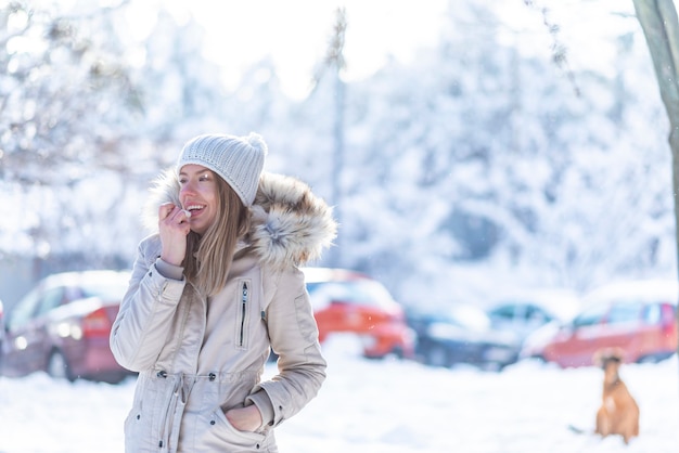 Photo portrait of a happy woman applying lip balm in winter