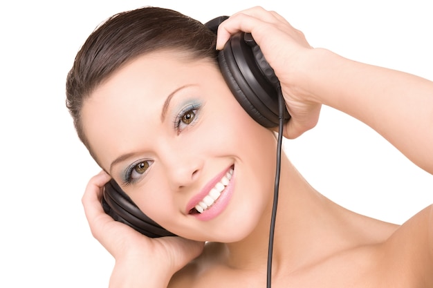 portrait of happy woman in headphones over white wall