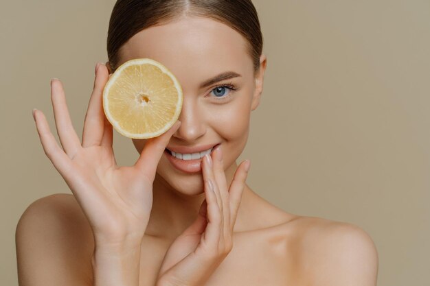 Photo portrait of happy woman holding apple against gray background