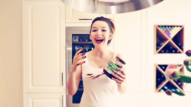 Foto ritratto di una donna felice con un contenitore di cioccolato in cucina a casa