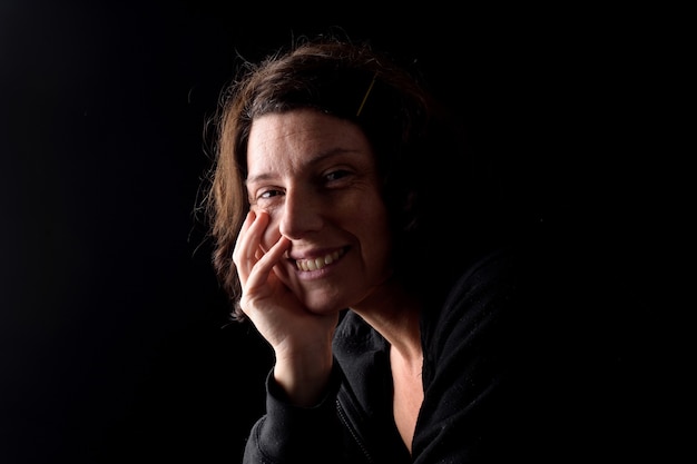 Portrait of a happy woman looking at camera on black bacground