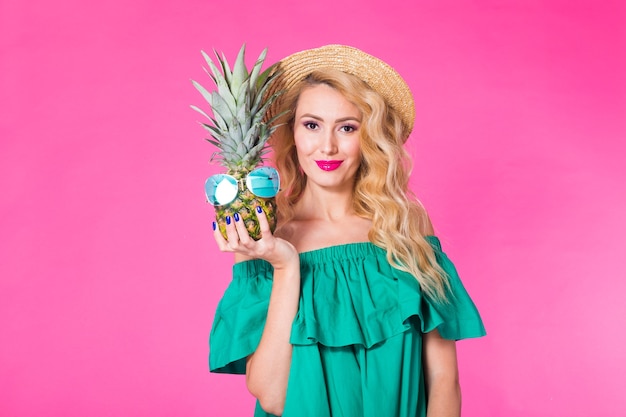 Portrait of happy woman and pineapple over pink background. Summer, diet and healthy lifestyle
