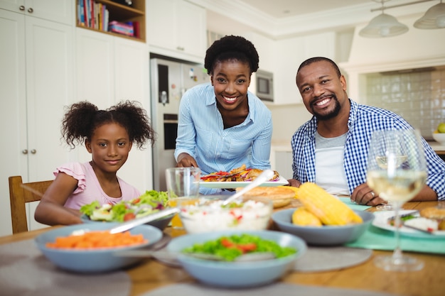 Portrait of happy woman serving food to the family