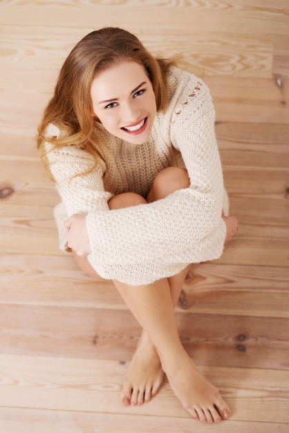 Photo portrait of happy woman sitting on hardwood floor at home