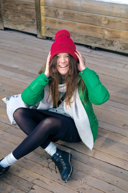 Portrait of happy woman sitting on wooden floor