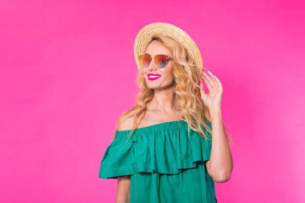 Photo portrait of happy woman in sunglasses on pink wall