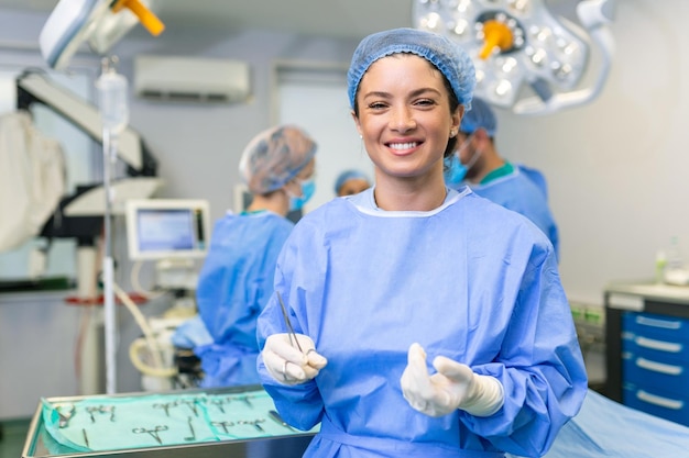 Ritratto di donna chirurgo felice in piedi in sala operatoria pronta a lavorare su un paziente operatrice medica in uniforme chirurgica in sala operatoria