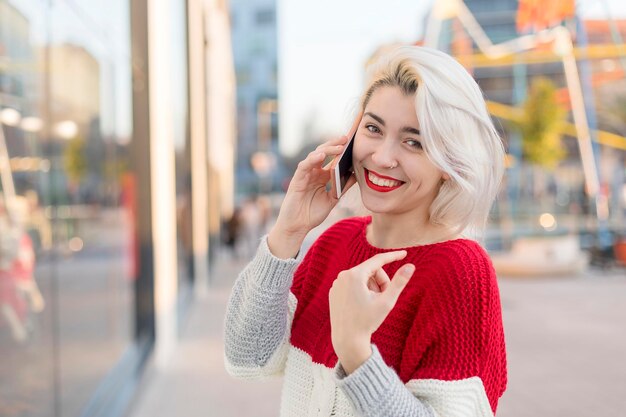 Portrait of happy woman talking on mobile phone in city