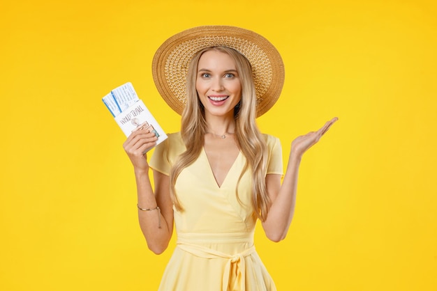 Portrait of happy woman traveller in summer clothes holding passport with plane tickets