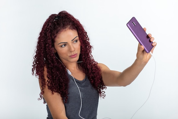 Photo portrait of a happy woman using cellphone and headphones