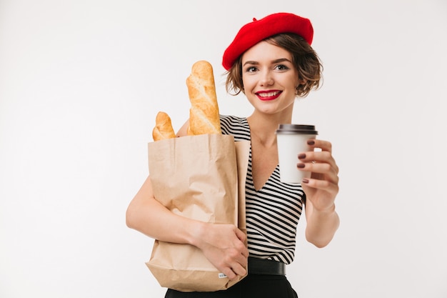 Portrait of a happy woman wearing beret holding paper bag