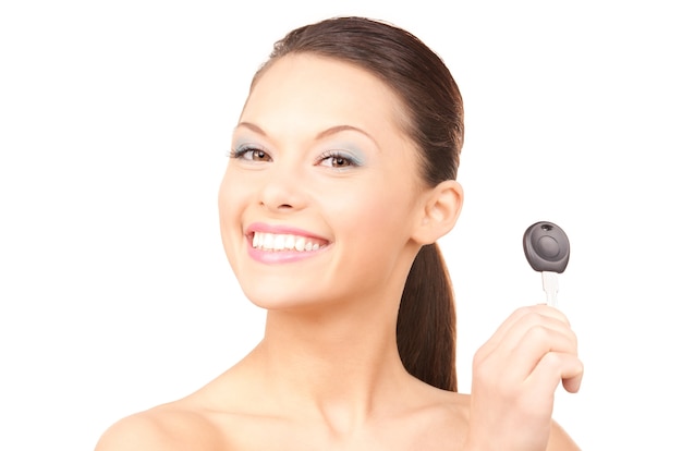 Portrait of happy woman with car key over white wall