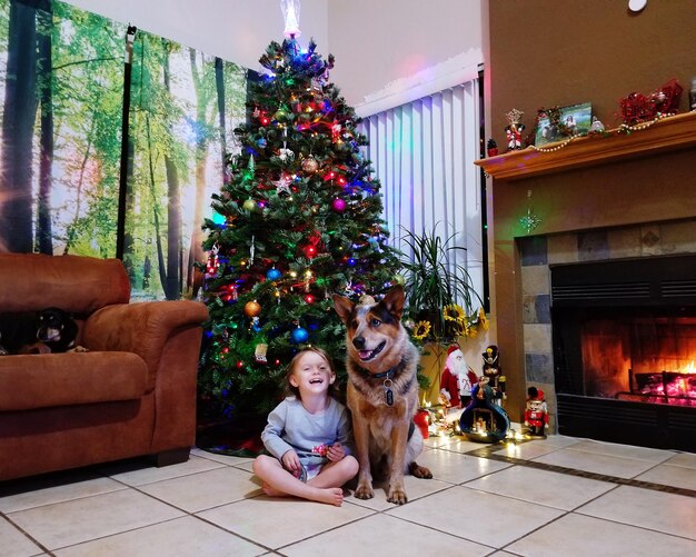 Portrait of happy woman with dog sitting on floor