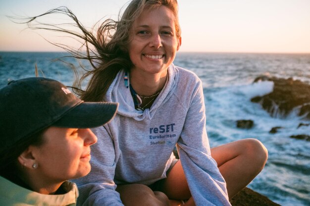 Photo portrait of happy woman with friend on shore