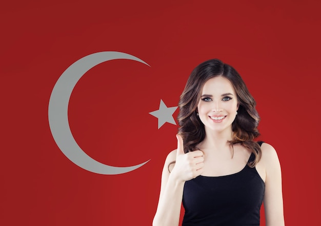 Portrait of happy woman with thumb up on Turkish flag background Travel in Turkey