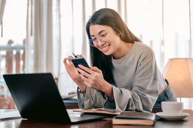 Portrait Happy woman working from homeShe using  smartphone chatting answer for customer