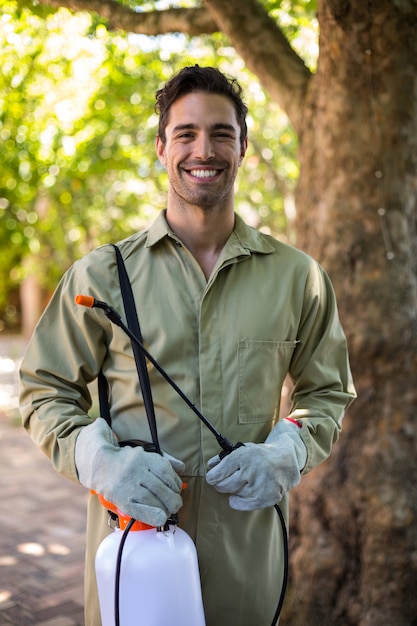 Portrait of happy worker with insecticide sprayer 