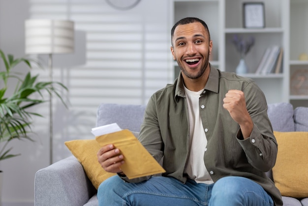 Portrait of happy young african american male student receiving good news from university holds a