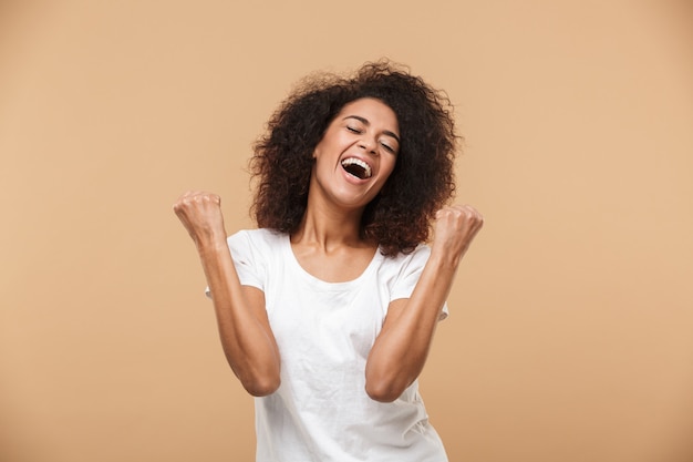 Portrait of a happy young african woman celebrating