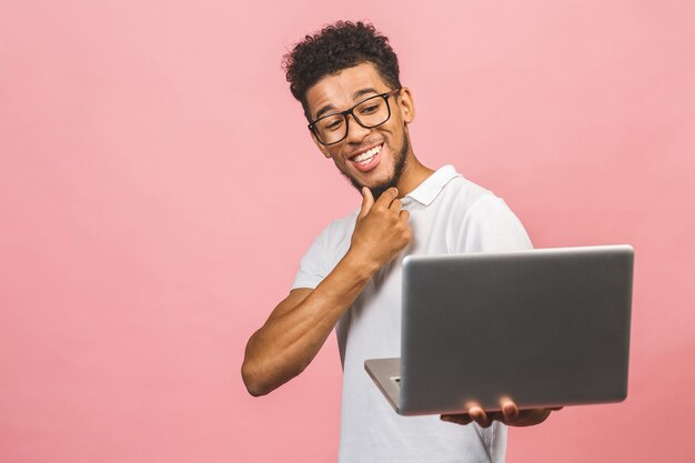 Portrait of happy young afro American man using laptop