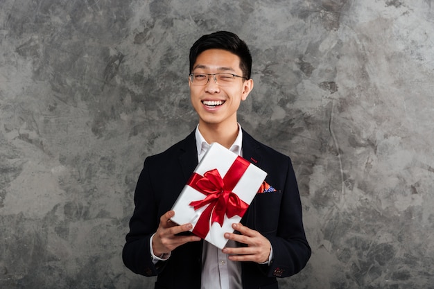 Portrait of a happy young asian man dressed in suit