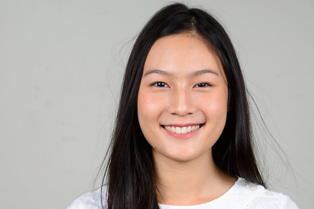 Portrait of happy young beautiful Asian woman