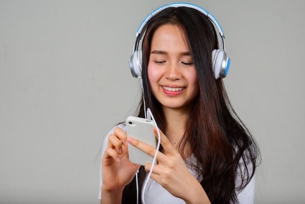 Portrait of happy young beautiful Asian woman