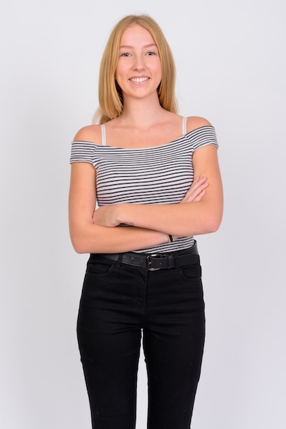 Portrait of happy young beautiful blonde teenage girl smiling with arms crossed