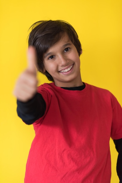 Portrait of a happy young boy in front of colored background