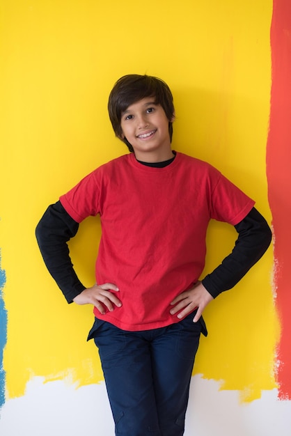 Portrait of a happy young boy in front of colored background