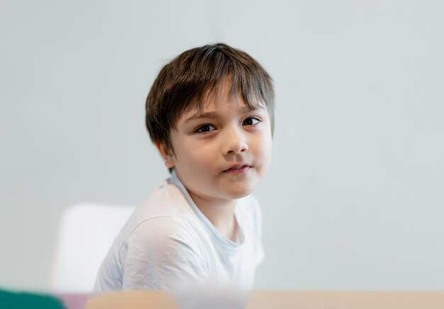 Photo portrait happy young boy looking at camera with smiling face child relaxing at home on weekend