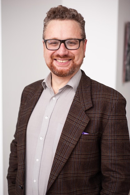 Portrait of happy young businessman in eyeglasses posing at camera and smiling isolated