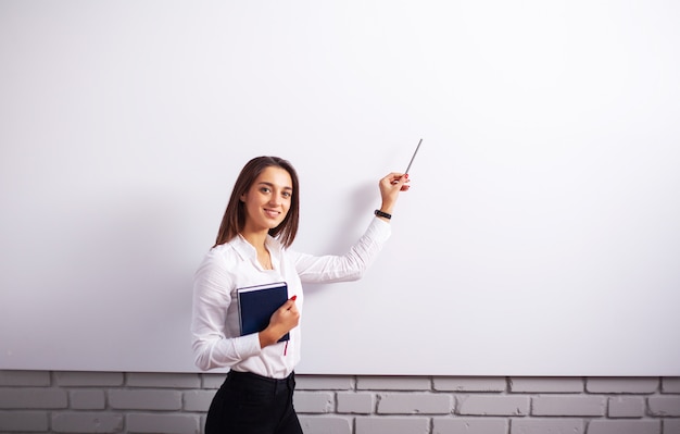 portrait of happy young businesswoman woman near on white wall