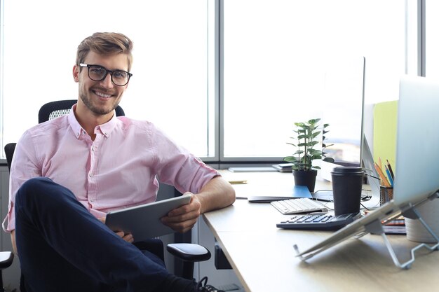 Portrait of a happy young casual businessman at office.