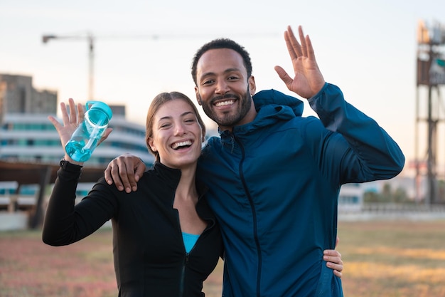 Portrait happy young couple ready to exercise outdoors