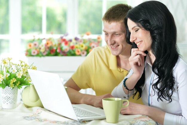 Photo portrait of happy young couple with laptop at home