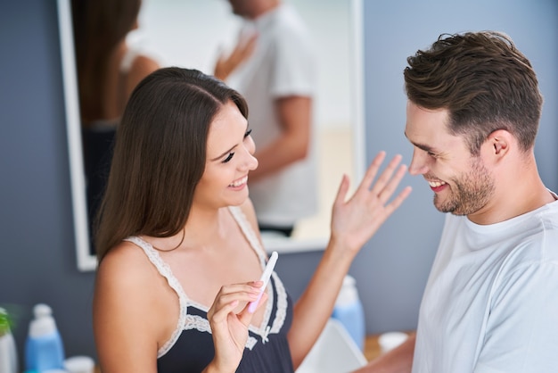 Portrait of happy young couple with pregnancy test in the bathroom