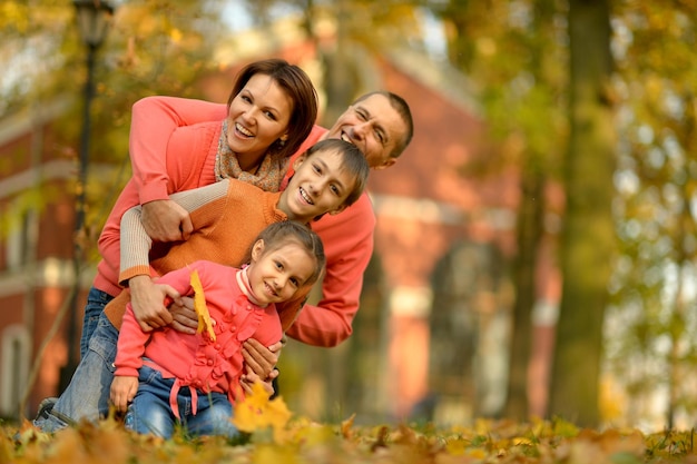 Ritratto di giovane famiglia felice nel parco autunnale