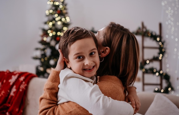 Portrait happy young family mother keeps in arms tender embrace gently hugs child kid son boy in chr