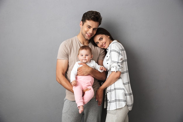 Портрет счастливой молодой семьи с их маленькой девочкой