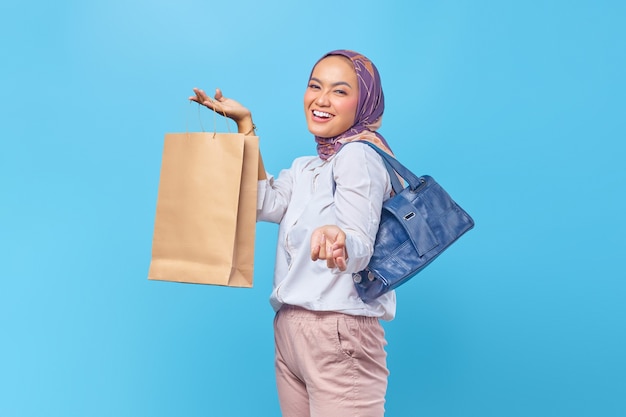 Portrait of happy young girl holding shopping bag