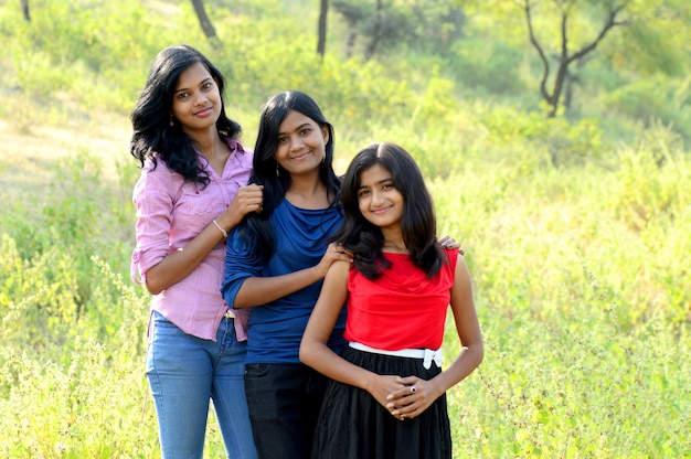 Portrait of happy young girls posing in park outdoors.