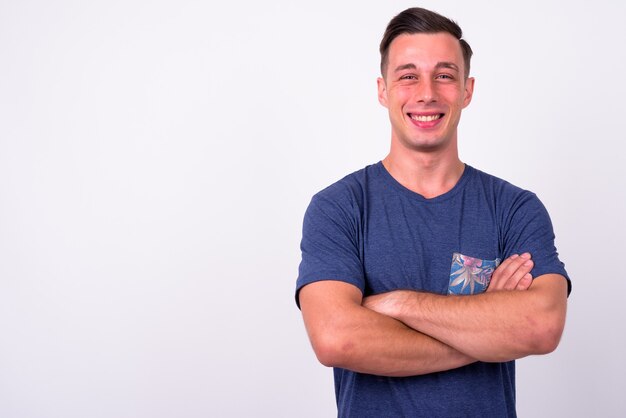 Portrait of happy young handsome man smiling with arms crossed