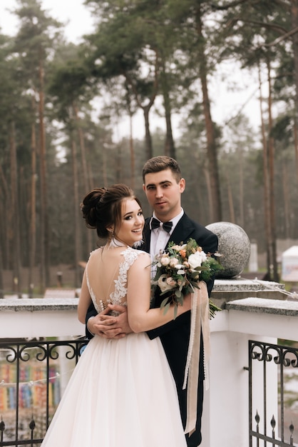 Portrait of happy young lovers of the bride and groom on the balcony of a beautiful hotel. Wedding day