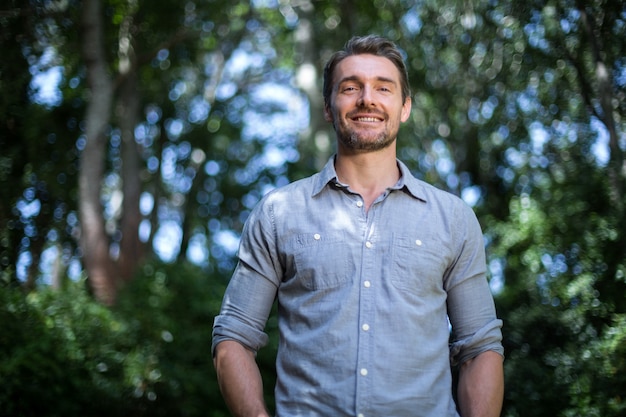 Portrait of happy young man against trees