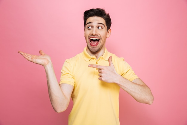 Portrait of a happy young man pointing