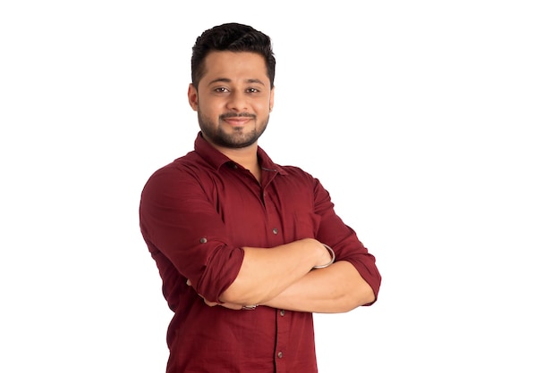 Portrait of a happy young man posing with arms crossed or hands folded on a white background