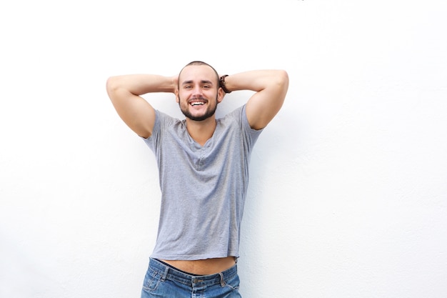 Portrait of a happy young man smiling with hands behind his head