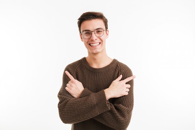 Портрет счастливого молодого человека в свитере указывая пальцами