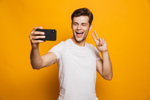 Portrait of a happy young man taking a selfie